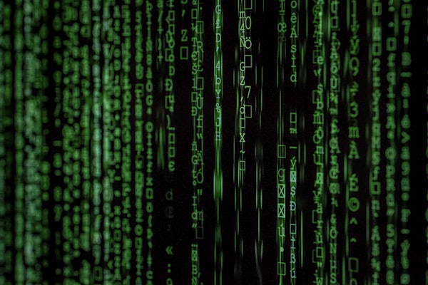 Abstract digital binary code projection on a dark surface, glowing red accents, highly technical, cyber aesthetic, no people
